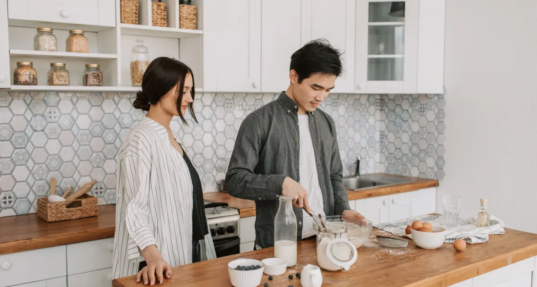 Couple preparing vegetables together at a kitchen island